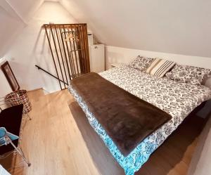 ein Schlafzimmer mit einem Bett mit einer Decke darauf in der Unterkunft Plongez dans le charme et le mystère de la maison Mythique in Andenne