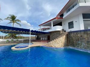 a swimming pool in front of a house at VILLA SIEMPRE DOMINGO in Tecuán