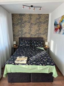 um quarto com uma cama com um edredão verde em Студио за нощувки Габрово em Gabrovo