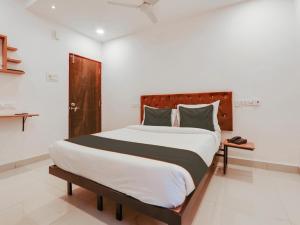 1 dormitorio con 1 cama grande y cabecero de madera en Super Collection O White Ridge Kamineni, en Hyderabad