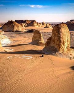 a desert with rock formations in the sand at Sand Rose Bahriya Hotel in Bawiti