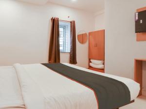 1 dormitorio con cama blanca y ventana en Super Collection O White Ridge Kamineni, en Hyderabad