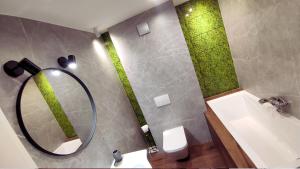 ein Badezimmer mit einem Spiegel, einem Waschbecken und einem WC in der Unterkunft Chwile w Starym Sączu, sauna i beczka in Stary Sącz