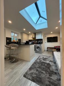a living room with a kitchen with a skylight at Exquisite 2 Bedroom Fully Furnished Annex in Bradenham