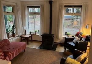 - un salon avec un canapé, des chaises et des fenêtres dans l'établissement De Compaenenhorst, à IJhorst