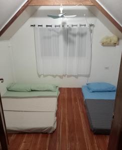 2 camas en una habitación pequeña con ventana en Wooden Guest House GASA en Dauis