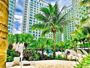 a view of a resort with palm trees and a beach at Azure Urban Resort Staycation By Owner Only in Manila