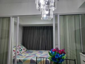 a bedroom with a bed and a chandelier at Azure Urban Resort Staycation By Owner Only in Manila