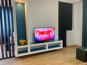 a flat screen tv sitting on a cabinet in a living room at Residencial Sol Point Art in Ponta do Sol