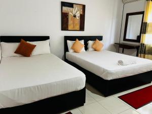 two beds in a small room with at Sobaya Residence in Ambalantota