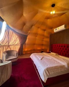 a bedroom with aamed ceiling with a bed and a chair at Wadi Rum alsultan Camp in Wadi Rum