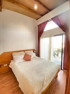 a bedroom with a bed and a large window at Hotel Costa Pichidangui in Pichidangui