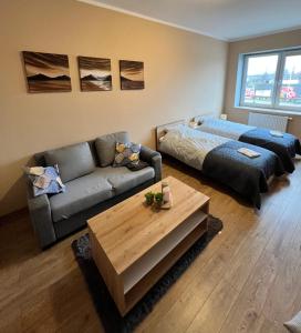 een woonkamer met een bank en een bed bij Gdynia Pokoje Blisko Morza i Centrum in Gdynia
