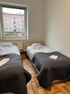 two beds in a room with a window at Gdynia Pokoje Blisko Morza i Centrum in Gdynia