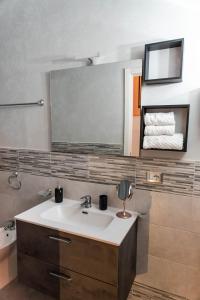 een badkamer met een wastafel en een spiegel bij Lannari 176 Casa vacanze Bagheria in Bagheria
