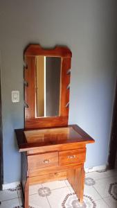 a wooden dresser with a mirror on a wall at Alvar Nuñez in Puerto Iguazú