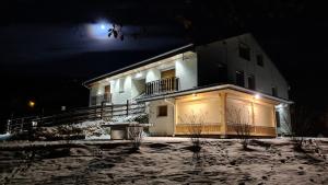 a large white building at night in the snow at MV Vacances in Les Rousses
