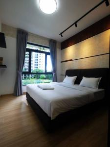 Un dormitorio con una cama grande con una ventana grande. en Peaceful Forestcity Ataraxia home, en Gelang Patah