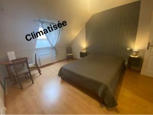 1 dormitorio con cama, mesa y ventana en AU FIL DES LACS, en Précy-Saint-Martin