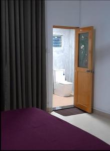 a bedroom with a door to a bathroom with a toilet at Sobaya Residence in Ambalantota