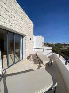 - un balcon avec une table et un banc dans un bâtiment dans l'établissement Dar Essa a Essaouira, personnel inclus, piscine chauffée, à Essaouira