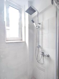 a shower in a white bathroom with a window at Steinstraße alt gelöscht in Bad Salzuflen