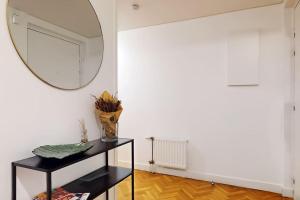 espejo en una pared en una habitación con mesa en JO2024-8Personne-Paris porte Italie-Moderne-Car Park and Wifi, en Le Kremlin-Bicêtre
