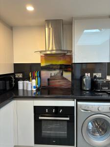 a kitchen with a stove and a dishwasher at Newly Build 2BR Property with free parking in High Wycombe