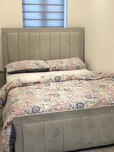 a bed with a quilt and pillows on it at Newly Build 2BR Property with free parking in High Wycombe