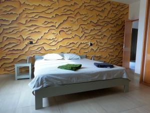 a bedroom with a bed and a wooden wall at Vila Babosa in Porto Novo