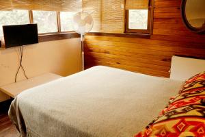 a bedroom with a bed and a fan and window at Cabañas Recanto in Mar del Plata