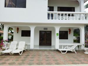 a white house with white chairs and a porch at Mi Paraíso de Playa Blanca in San Antero