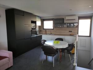 eine Küche mit einem Tisch und Stühlen im Zimmer in der Unterkunft L'Orlu Chambres D'Hotes proximité plage in Canet-en-Roussillon