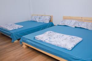 3 camas en una habitación con sábanas azules en Đồi Thông Homestay, en Làng Me