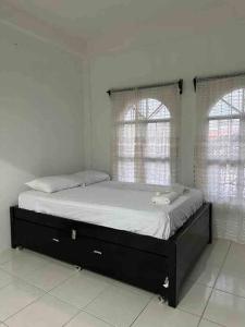 uma cama num quarto com duas janelas em Casa Maya em Palenque