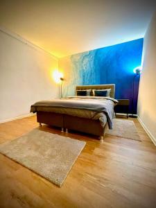 a bedroom with a bed with a blue wall at Apartman BRONX Prijedor in Prijedor