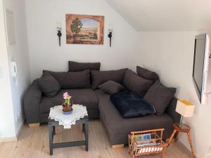 uma sala de estar com um sofá castanho e uma mesa em Ferienwohnung Rhönperle Dermbach em Dermbach