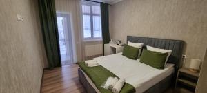 a bedroom with a large bed with green pillows at Tsaghkunk Chef House Hotel & Restaurant in Sevan