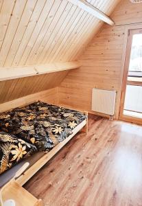 1 dormitorio con 1 cama en una habitación con paredes de madera en Sielanka u Basi en Toporzysko