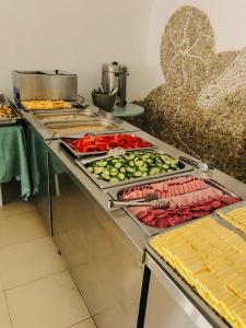 a kitchen with several trays of vegetables on a counter at Mint Family Hotel in Ravda