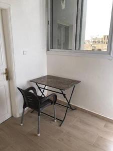 a table and a chair in a room with a window at Chambre tout confort avec salle de bain intérieure privée - Clim & breakfast in Saint-Louis