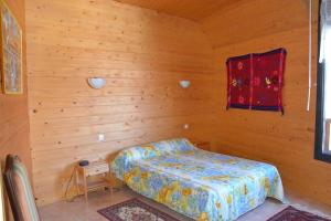 1 dormitorio con 1 cama en una habitación de madera en Chalet 12 places à 5 mn St Lary, en Camparan