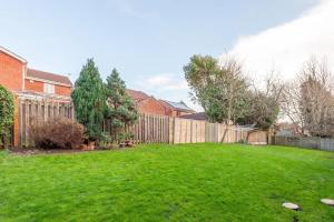 a backyard with a fence and a green yard at Pass the Keys Cosy Haven next to White Rose Shopping Centre in Leeds