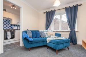 a living room with a blue couch and a window at Pass the Keys Cosy Haven next to White Rose Shopping Centre in Leeds