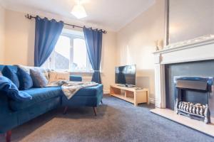 a living room with a blue couch and a fireplace at Pass the Keys Cosy Haven next to White Rose Shopping Centre in Leeds
