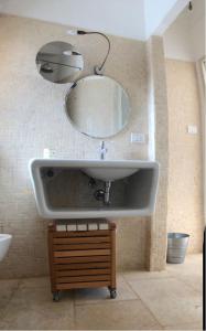 a sink in a bathroom with a mirror at Feudo Frammasi - Curte Glamping Experience in Salve