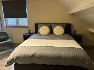 a bedroom with a large bed with two pillows at De Kempische Akker in Westerlo