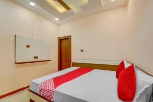 1 dormitorio con 1 cama con almohadas rojas en OYO Flagship Relax Inn, en Dhanbād