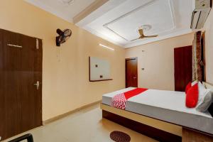 1 dormitorio con cama, ventana y puerta en OYO Flagship Relax Inn, en Dhanbād
