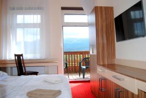 sypialnia z łóżkiem i biurkiem oraz balkon w obiekcie Willa Nimfa - dla Grup i Gości indywidualnych w Szklarskiej Porębie